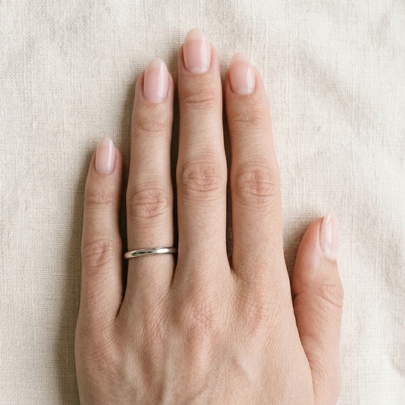 A hand wearing a plain band, shown at actual size