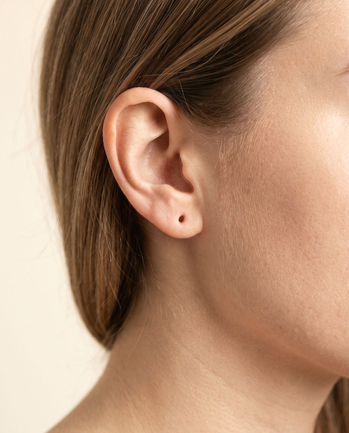 A diamond stud shown on an ear, approximate size